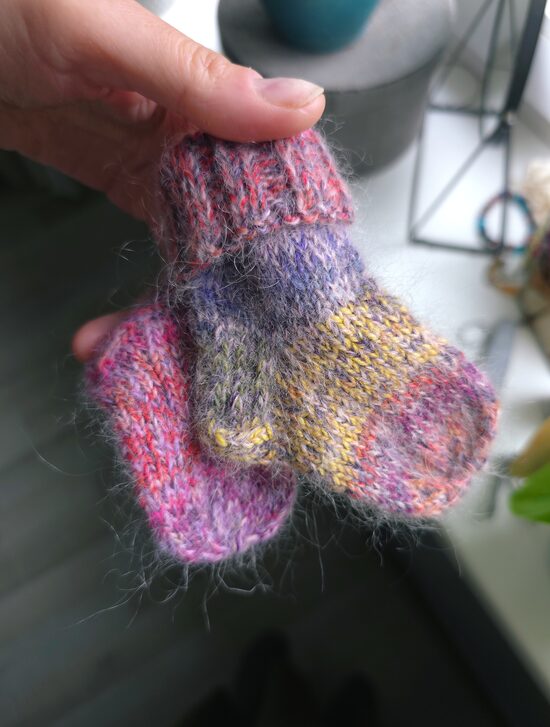 Koši raibas ar rokām adītas mazuļu vilnas zeķes