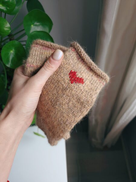 Bēši adīti bezpirkstu cimdi ar sarkanu sirsniņu